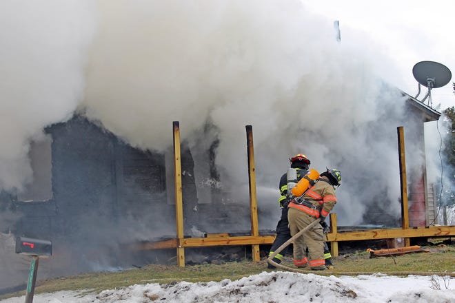 Moscow Township firefighters battle the blaze from the front side of the home. [COREY MURRAY PHOTO]