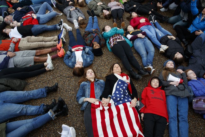 Abby Spangler and her daughter Eleanor Spangler Neuchterlein, 16, hold hands as they participate in a "lie-in" during a protest in favor of gun control reform in front of the White House on Monday in Washington. [AP Photo / Evan Vucci]