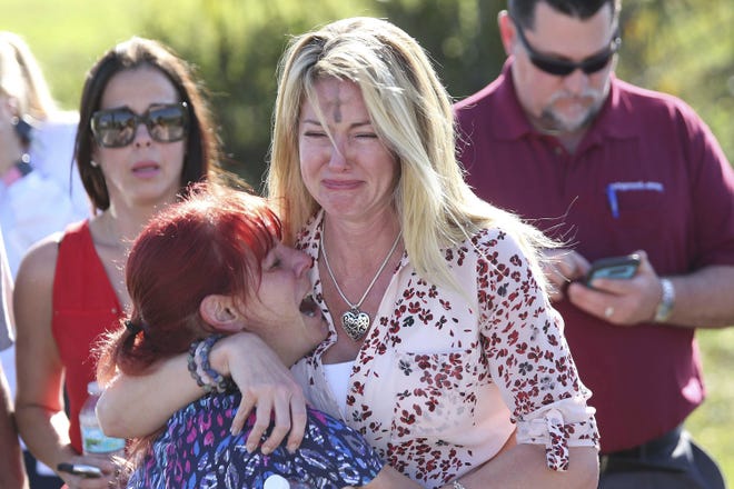 Parents wait for news after a reports of a shooting at Marjory Stoneman Douglas High School in Parkland, Fla., on Wednesday, Feb. 14, 2018. (AP Photo/Joel Auerbach)