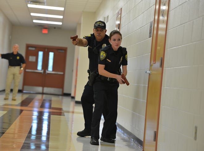 Leesburg, Florida, police officers advance down a hallway toward a room during an active shooter training drill at Leesburg High School. [GateHouse Media Archive]