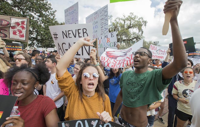 Therese Gachnauer, center, an 18-year-old senior from Chiles High School, and Kwane Gatlin, right, a 19-year-old senior from Lincoln High School, both in Tallahassee, join fellow students protesting gun violence on the steps of the old Florida Capitol on Wednesday. [Mark Wallheiser/AP]