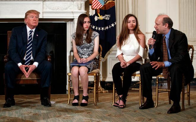 From left, President Donald Trump, Marjory Stoneman Douglas High School student students Carson Abt, and Ariana Klein, listen as Carson's father Frederick Abt, speaks during a listening session with high school students, teachers, and others in the State Dining Room of the White House in Washington, Wednesday, Feb. 21, 2018. In the aftermath of yet another mass school shooting, Trump says that if one of the victims, a football coach, had been armed â€œhe would have shot and that would have been the end of it.â€ Revisiting an idea he raised in his campaign, Trumpâ€™s comments in favor of allowing teachers to be armed come as lawmakers in several states are wrestling with the idea, including in Florida, where the 17 most recent school shooting victims are being mourned.(AP Photo/Carolyn Kaster)
