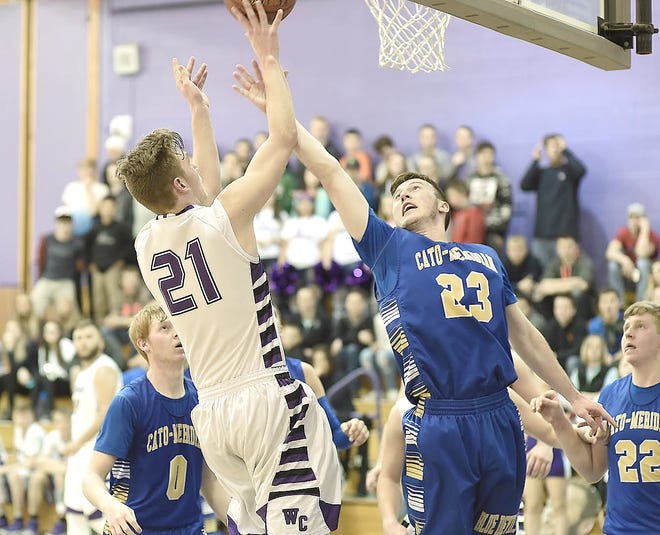 Cory Collard (21) puts up a shot in the second half for West Canada Valley Tuesday with Aidan Crandall defending for Cato-Meridian.      

[Photo Courtesy of Bob Critser, digitalsportsphotography.net]