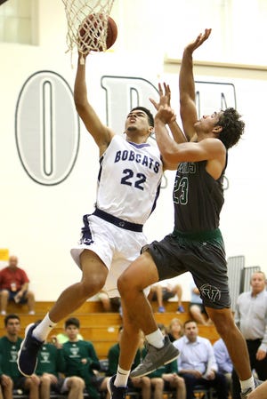 North Port's Aaron Dismukes (22) drives to the basket against Venice's Jaivin Heiligh (23) Thursday at North Port High School. The Bobcats won in overtime 56-55. [Herald-Tribune photo / Matt Houston]