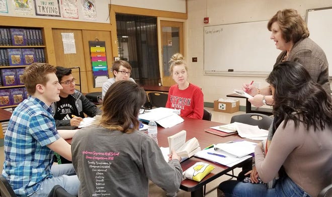 Retired French teacher Mary Ebert, standing, shares a lesson with, from her right, counterclockwise, fourth-year French students Brooklyn Pickering, Albert Kelley, Nick Sierra, Cullen Marshall, Stephanie Alejandre and Joseline Castillo. Not pictured is student Josie Heeren.