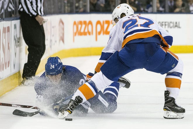 Maple Leafs' Kasperi Kapanen is sprayed with ice as he battles for the puck with Islanders' Anders Lee during the second period of Thursday night's game in Toronto. [Chris Young/The Canadian Press via AP]