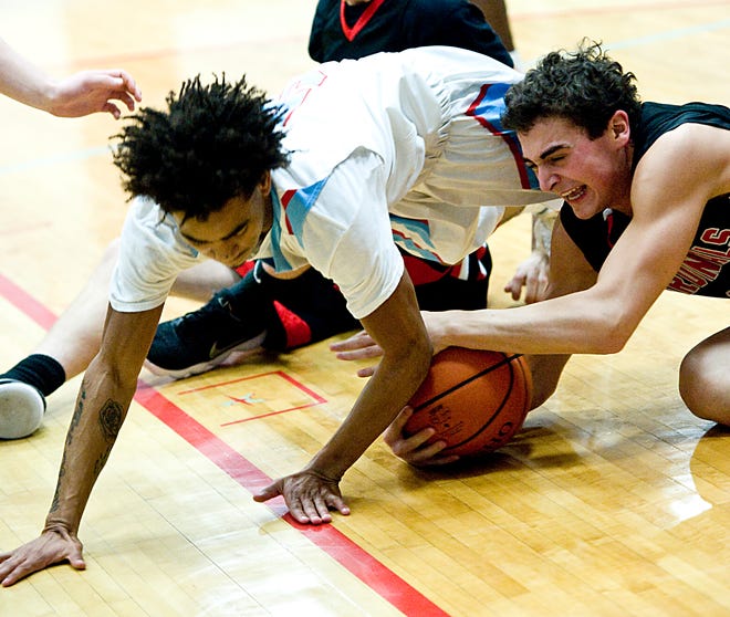 Alliance's Demarko Brooks, left, scrambles for a loose ball with Canfield's Ben Shapiro Friday, February 23, 2018 in a boys varsity basketball game at Alliance High School. Michael Skolosh, The-Review.com