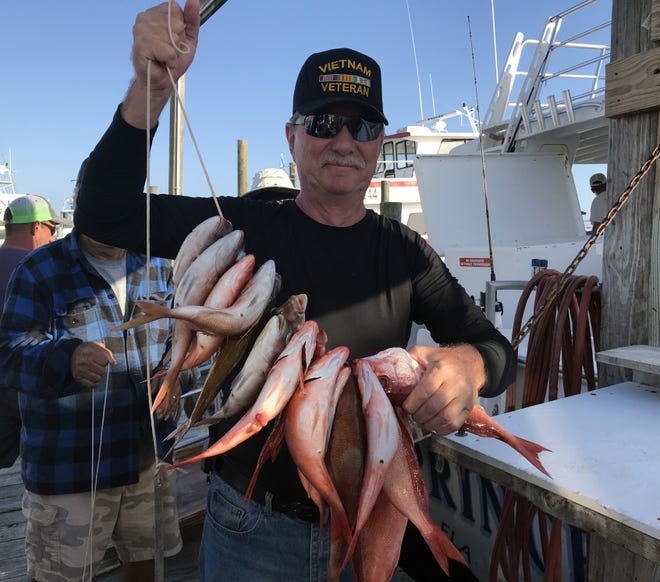 Pete Sawicki of New York shows off his stringer filled with mingo and white snapper. He was fishing aboard the Destin Princess on Thursday with Capt. Chris McConnell. [TINA HARBUCK/THE LOG]