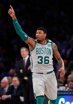 Boston Celtics guard Marcus Smart celebrates toward Celtics fans during the first half of the team's NBA basketball game against the New York Knicks in New York, Saturday, Feb. 24, 2018. The Celtics defeated the Knicks 121-112. (AP Photo/Kathy Willens)