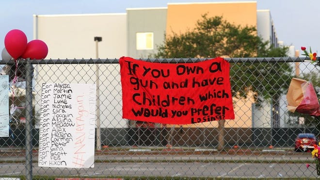 A sign was draped outside Marjory Stoneman Douglas High School in Parkland, Florida, as teachers returned to campus more than week after a deadly shooting barrage at the school.