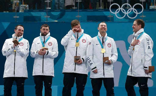 Gold medal winners from left: United States' curlers Joe Polo, John Landsteiner, Matt Hamilton, Tyler George, John Shuster and captain Phill Drobnick stand on the podium during the men's curling venue ceremony at the 2018 Winter Olympics in Gangneung, South Korea, Saturday, Feb. 24, 2018. (AP Photo/Natacha Pisarenko)