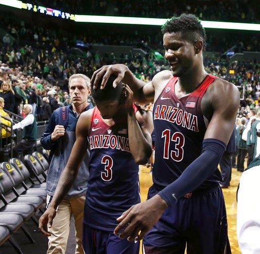 Arizona's Dylan Smith, left, and DeAndre Ayton leave the court after the team's 98-93 overtime loss to Oregon in an NCAA college basketball game Saturday, Feb. 24, 2018, in Eugene, Ore. (AP Photo/Chris Pietsch)