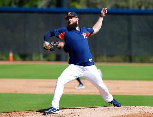 FILE - In this Feb. 19, 2018, file photo, Houston Astros pitcher Dallas Keuchel takes part in a drill during spring training baseball practice, in West Palm Beach, Fla. Keuchel has won a Cy Young Award and a World Series. Despite his success, the left-hander believes there's so much more to learn and is constantly studying the habits and routines of his Houston teammates hoping to pick up something that will help him improve. (AP Photo/Jeff Roberson, File)