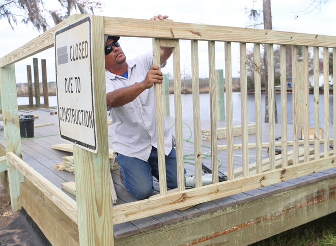 Nathan Floyd works on a hand rail of a new fishing dock Wednesday at David W. Hutchison Park. The public park along County 2301 in Bayou George is undergoing renovations. [PATTI BLAKE/THE NEWS HERALD]