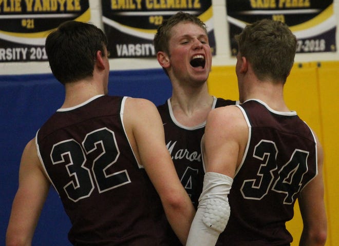 Holland Christian’s Vince Overway chest bumps with teammates Levi VanDam (left) and Chris Mokma after a basket in the second half in a win at NorthPointe Christian. [Chris Zadorozny/Sentinel staff]