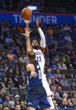 Oklahoma City Thunder's Paul George (13) shoots over Orlando Magic's Evan Fournier (10) in the second half of an NBA basketball game in Oklahoma City, Monday, Feb. 26, 2018. (AP Photo/Kyle Phillips)