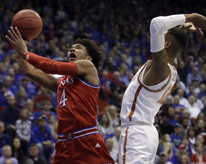 Kansas guard Devonte' Graham (4) shoots while covered by Texas guard Kerwin Roach II (12) Monday during the first half in Lawrence. It was Graham's final game in Allen Fieldhouse. [THE ASSOCIATED PRESS]