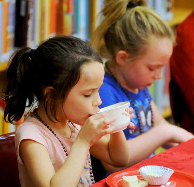Yeraldi Loar (left), 8, and Hailey Wilson, 7, participate in an afternoon tea Tuesday at Cottonwood Elementary School. [TOM DORSEY / SALINA JOURNAL]