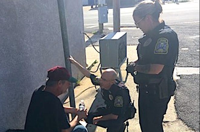 From right, Officers Christina Dawson and Corey Newcomb speak with a homeless man who said he had not eaten in a long time, according to the officers. [Photo by NATE MARLAR | Crestview Police Department]