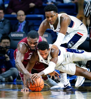 Connecticut's Christian Vital (1) and Temple's Ernest Aflakpui (24) chase down a loose ball with Connecticut's Josh Carlton (25) following up in the first half of an NCAA college basketball game Wednesday, Feb. 28, 2018, in Storrs, Conn. (AP Photo/Stephen Dunn)