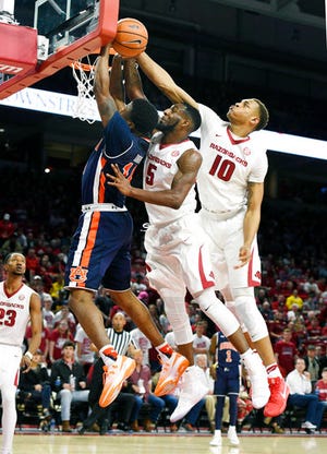 Auburn guard Malik Dunbar has his shot blocked by Arkansas defenders Arlando Cook (5) and Daniel Gafford (10) as he tries to drive to the hoop during the first half of an NCAA college basketball game Tuesday, Feb. 27, 2018, in Fayetteville, Ark. (AP Photo/Michael Woods)