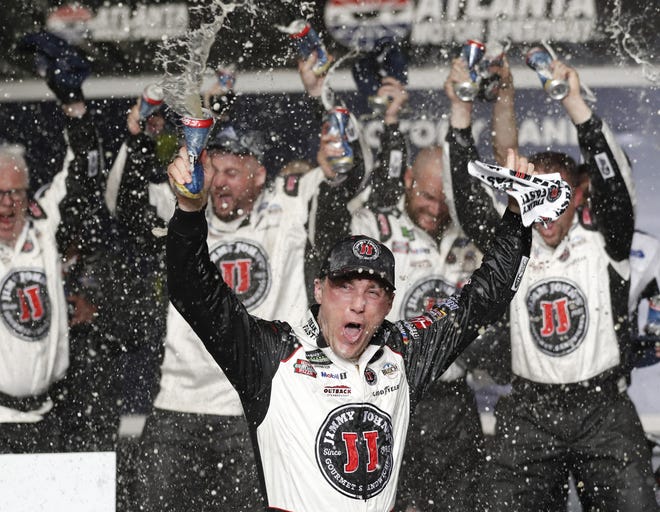 Kevin Harvick (front) reacts after winning the NASCAR Cup Series auto race at Atlanta Motor Speedway in Hampton, Ga., on Sunday. [The Associated Press / John Bazemore]