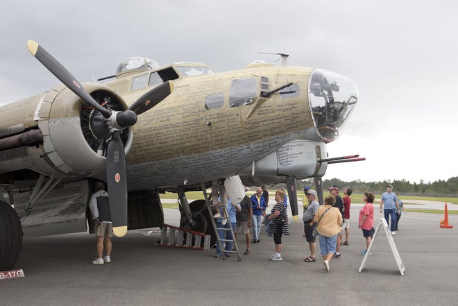 People climb inside a B-17 Flying Fortress during the Wings of Freedom tour Wednesday at Sheltair, at Northwest Florida Beaches International Airport. The tour features restored World War II aircraft, including the P-51 Mustang, B-24 Liberator and the B-17. [JOSHUA BOUCHER/THE NEWS HERALD]