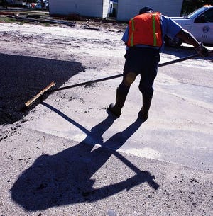 A Panama City streets division employee grades a section of new pavement. The city will spend over $300,000 this year on road paving. [NEWS HERALD FILE PHOTO]