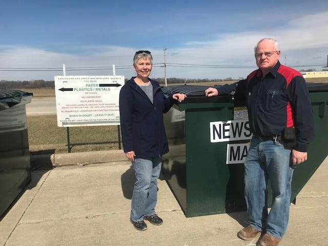 Mitzi Rohlfs, left, Coordinator for the Logan County Joint Solid Waste Agency and Bob Rankin, with Big R, stands near the recycling containers that are located between the store and Burger King along Route 10 in Lincoln. [Photo by Jean Ann Miller/The Courier]