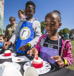 Khelan and Ziyen Woods decorate strawberry cupcakes at last year's Strawberry Festival. The festival's fifth edition runs Saturday at the McPherson Governmental Complex in Ocala. [File photo]