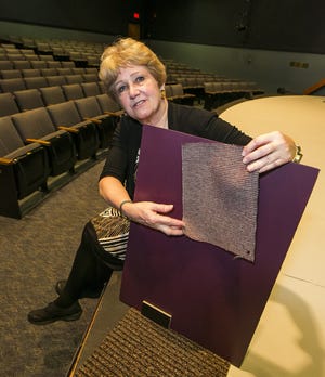 Ocala Civic Theatre is raising money to pay for interior renovations, primarily new, wider seats with cup holders. Executive Director Mary Britt shows what color the walls will be along with new baseboard, carpet and seating material. The house will go from 401 to 350 because of the wider seats. [Doug Engle/Staff photographer]