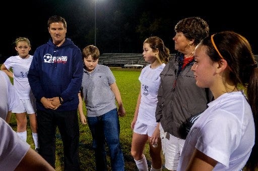 Miller Molnar, 14, leans on his dad, Terry Sanford girls' soccer coach Karl Molnar, after a game. The family incorporates Miller's diagnosis of autism into their busy lives. [RODD BAXLEY/THE FAYETTEVILLE OBSERVER]