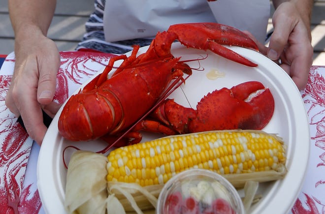 A lobster is served at cookout in Boothbay, Maine. Regulators in the state that dominates the U.S. lobster haul said the lobster catch fell to its lowest level since 2011 last year, but the industry remains strong. [ROBERT F. BUKATY/AP]