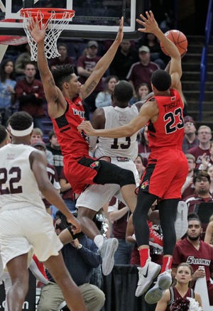 Southern Illinois' Sean Lloyd Jr. (13) is rejected by Illinois State's William Tinsley (23) and Phil Fayne during the second half of an NCAA college basketball game in the semifinals of the Missouri Valley Conference tournament, Saturday, March 3, 2018, in St. Louis. (AP Photo/Tom Gannam)