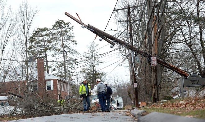 A utility pole and tree limbs stretch across Auburn Street in Framingham Saturday as cleanup from Friday's storm continued. [Daily News Staff Photo/Ken McGagh]