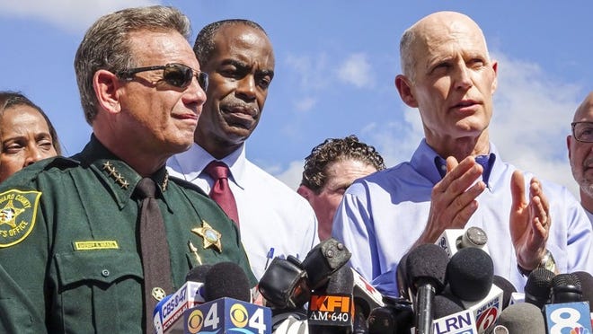 Broward County Sheriff Scott Israel and Broward County Schools Superintendent Robert W. Runcie listen as Florida Gov. Rick Scott speaks during a press conference outside Marjory Stoneman Douglas High School Thursday morning, February 15, 2018, the day after former student Nikolas Cruz returned to the school and is accused of killing 17 people. (Lannis Waters / The Palm Beach Post)