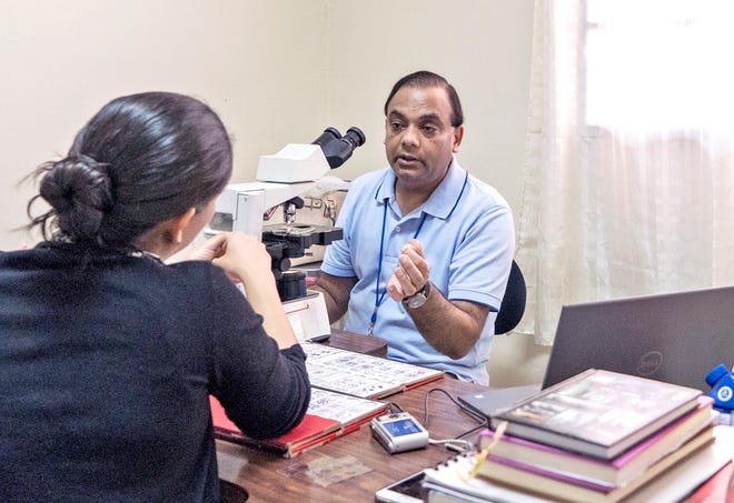 Dr. Arun Masih teaching and doing a question-and-answer session in the pathology lab in Honduras.