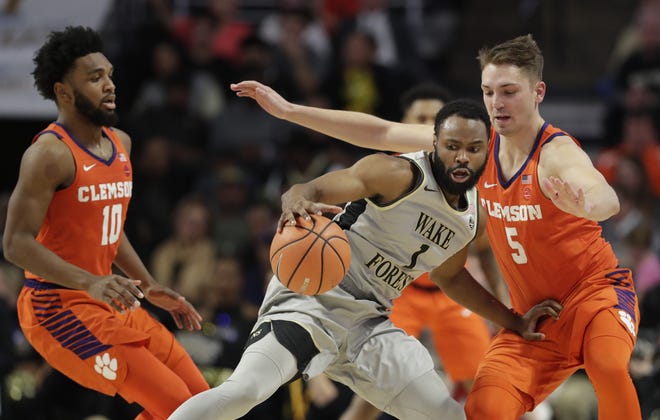 Wake Forest's Keyshawn Woods (1), a former Gaston Day standout, drives against Clemson's Mark Donnal (5) and Shelby's Gabe DeVoe (10) during the second half of Clemson's 75-67 win over the Deacons in Winston-Salem on Feb. 3. [AP Photo/Chuck Burton]