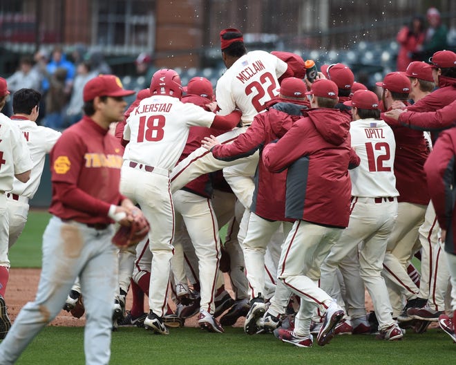 The Arkansas Razorbacks celebrate after a walk-off single by pinch hitter sophomore out-fielder Dominic Fletcher in the bottom of the 8th to beat the Trojans, 7-6, on Sunday, March 4, 2018, at Baum Stadium. The Hogs took the 3 game series 2-1 and are now 9-3 overall for the season. [CRAVEN WHITLOW/SPECIAL TO NATE ALLEN SPORTS SERVICE]