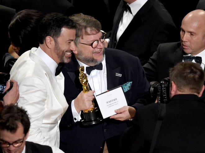 Jimmy Kimmel, left, congratulates Guillermo del Toro in the audience after winning the award for best picture for "The Shape of Water" at the Oscars on Sunday, March 4, 2018, at the Dolby Theatre in Los Angeles. (Photo by Chris Pizzello/Invision/AP)