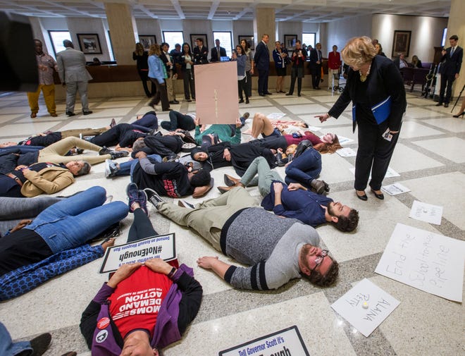 Florida Rep. Janet Cruz, D-Tampa, walks around a group of 20 college students and activists as they stage a "die-in" Tuesday between the House and Senate chambers while the House takes up a school safety bill that includes a lot for both sides to like — and to hate. [AP Photo/Mark Wallheiser]