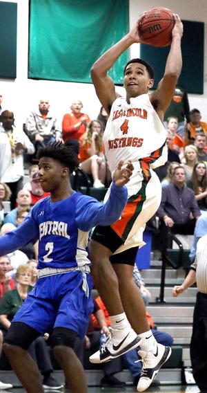 East Lincoln's Sidney Dollar shoots over Tyion Watkins during their 69-59 Feb. 24 N.C. 2A playoff win over R-S Central at East Lincoln High School. Dollar was named South Fork 2A Conference boys basketball player of the year. [JOHN CLARK/THE GASTON GAZETTE]