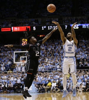 North Carolina's Joel Berry II (2) shoots while Miami's Chris Lykes (2) defends during Miami's 91-88 win at North Carolina on Feb. 27. Berry will be one of the participants in the April 18 ACC barnstorming tour at Hunter Huss High School. [AP Photo/Gerry Broome]
