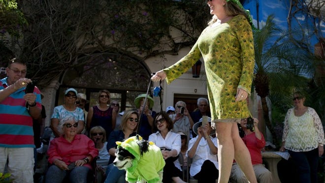 Dressed as dragons Terriann Fischer, of West Palm Beach, and her dog Wilbert walk the Worth Avenue’s 23rd annual Pet Parade and Contest in Via Amore off Saturday March 11 , 2017. (Meghan McCarthy / Daily News)