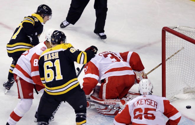 Bruins defenseman Torey Krug, top left, watches his shot slip past Red Wings goaltender Jared Coreau (31) for a first-period goal, his second of the game, on Tuesday.