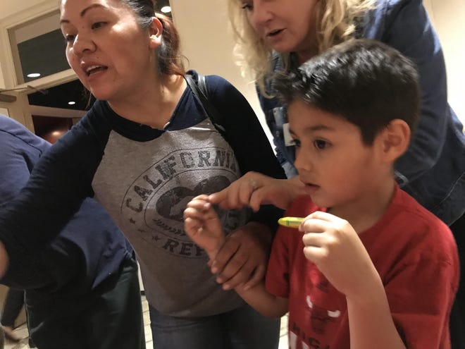 Marbelia Ayala and her son Jesus work on a heart-drawing activity Tuesday night at the Soar in 4 event at Bradenton’s South Florida Museum. [HERALD-TRIBUNE PHOTO / Ryan McKinnon]