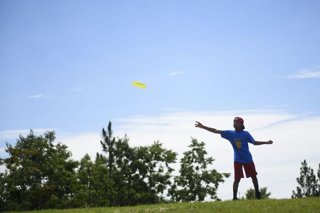 Danavan Curry, 10, throws a Frisbee during play outdoors for campers at a Boy Scout Camp for Fayetteville area scouts June 26, 2017. [Melissa Sue Gerrits/The Fayetteville Observer]