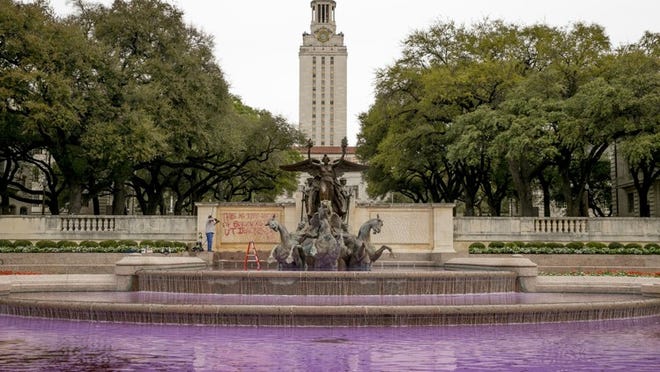 Graffiti is removed from the Littlefield Fountain on the UT campus on Thursday. It says “This is the blood of survivors that UT ignores.” JAY JANNER / AMERICAN-STATESMAN