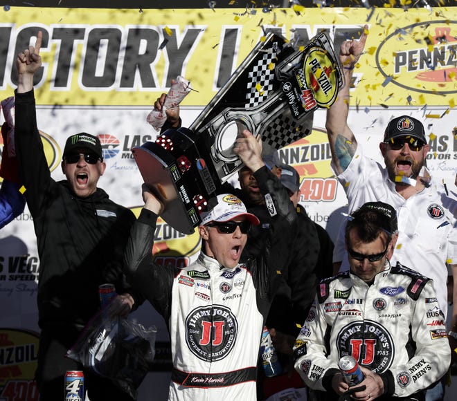 Kevin Harvick hoists the trophy with his team after winning a NASCAR Cup series auto race Sunday in Las Vegas. Harvick is bidding for his third staright win this week. [AP Photo / Isaac Brekken]