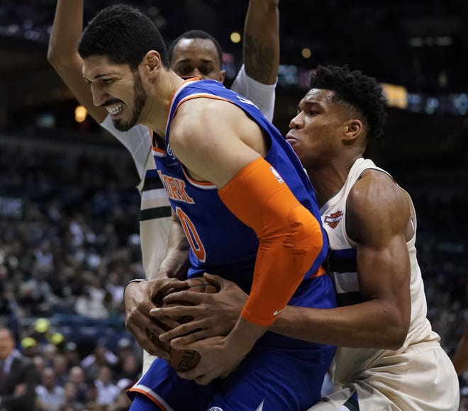 Bucks' Giannis Antetokounmpo, right, ties up Knicks' Enes Kanter during the first half of Friday night's game in Milwaukee. [The Associated Press]